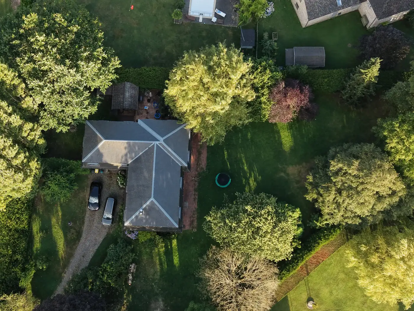 Vue zénithale par drone d'une parcelle résidentielle arborée avec villa et jardin, Brabant wallon